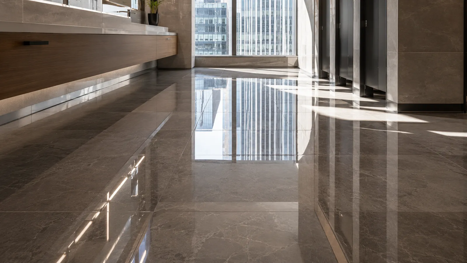 The same corporate restroom tile floor with a bright, reflective finish after Duralyx Crystl Bond™ treatment.